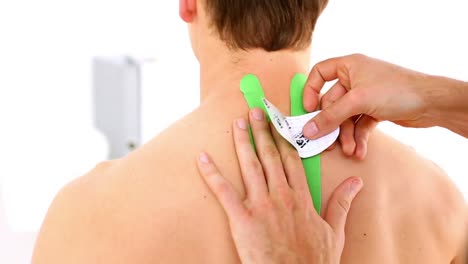 physiotherapist applying green kinesio tape to patients back