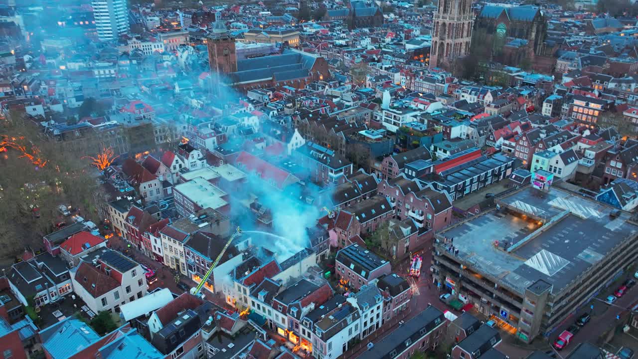 Esplosione di fuoco e gas a Utrecht, centro città fumante, Paesi Bassi, pompiere che spegne il fuoco da una gru dei vigili del fuoco, vista aerea con drone sul centro storico