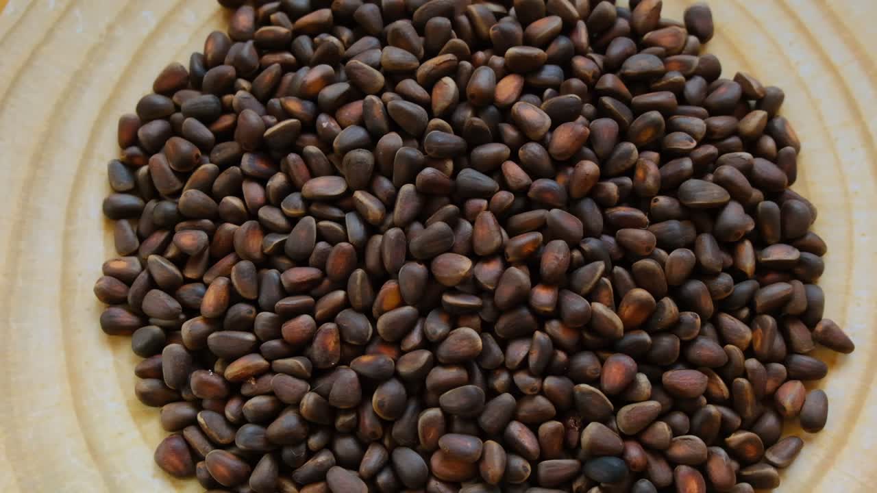 둥근 접시에 있는 소나무 견과류. 회전. 견과류와 씨. 소나비 견과류의 어리. 건강한 지방. 건강한 간식