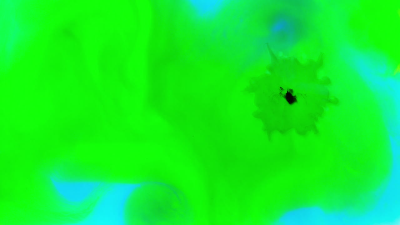 disparo aéreo de gotas de pintura o tinte verde y azul caídas en el agua contra un fondo blanco para crear un patrón de colores giratorios
