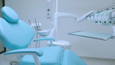 práctica dental moderna. silla dental y otros accesorios utilizados por los dentistas en azul, luz médica.