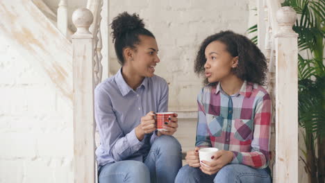 two teen girls talking on stairs