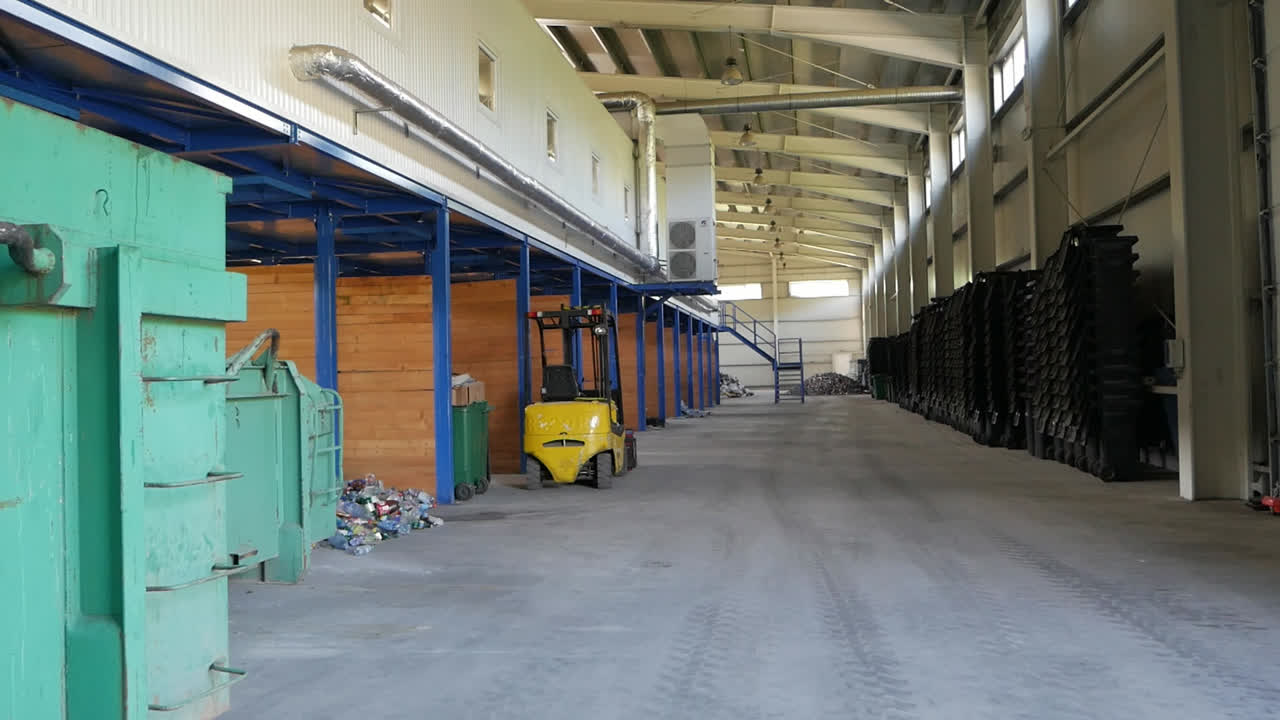 Empty industrial warehouse interior with clean concrete floor and blue metal storage racks