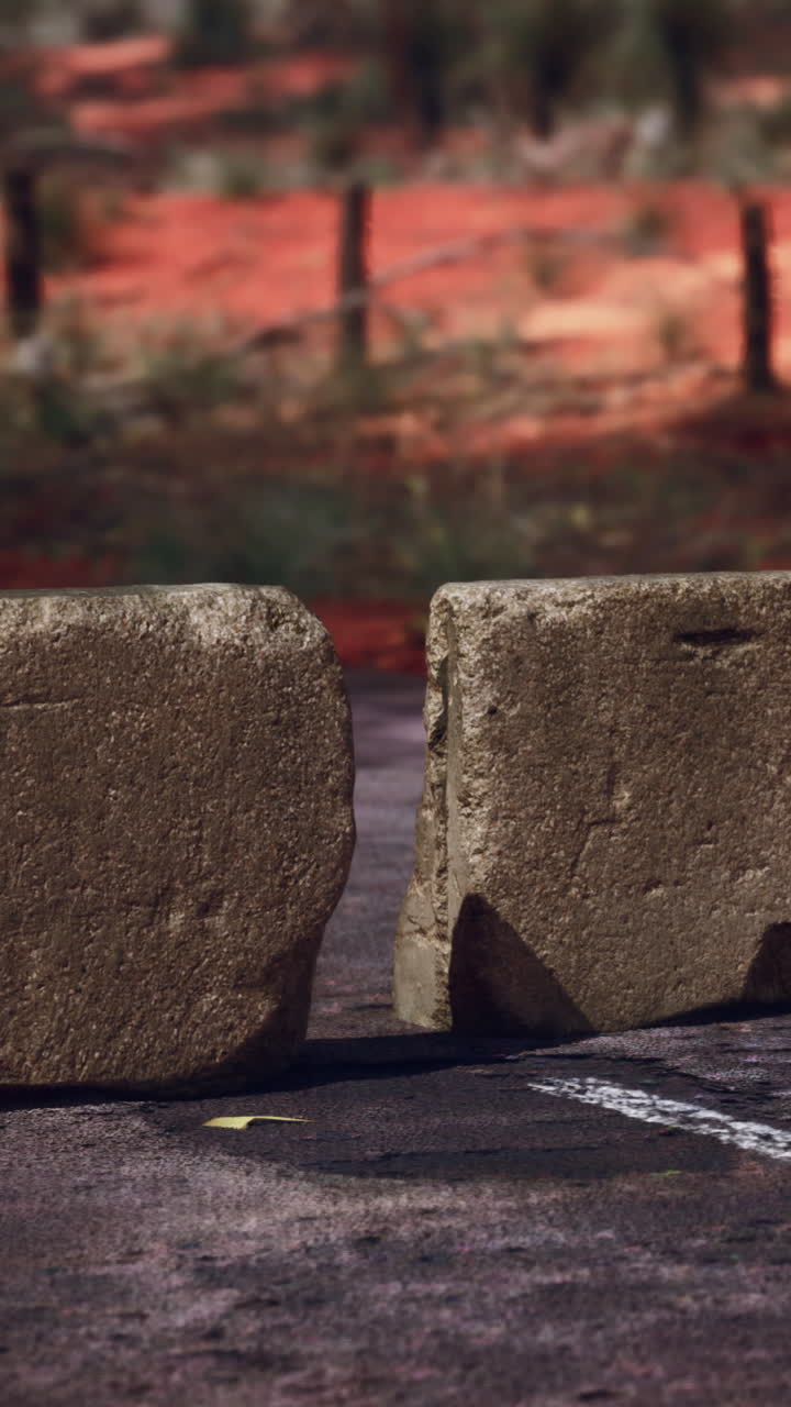 una barrera de hormigón rota en un camino polvoriento