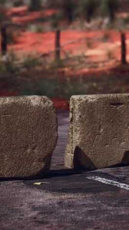 a broken concrete roadblock on a dusty road