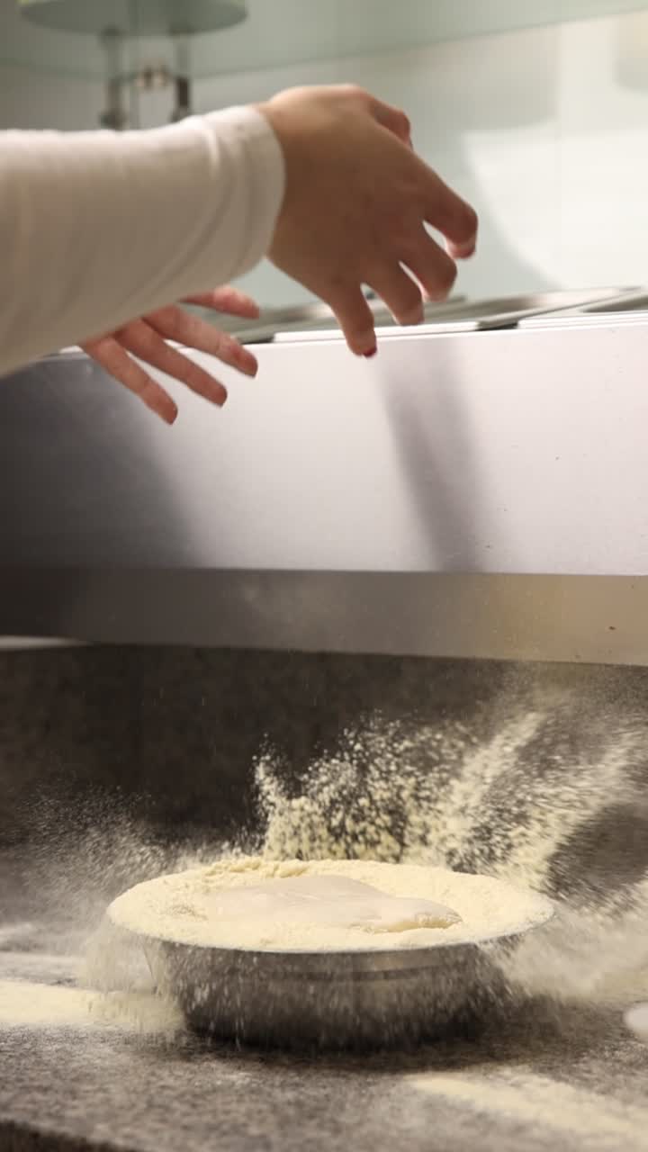 Chef's Hands Dipping Pizza Dough in Flour
