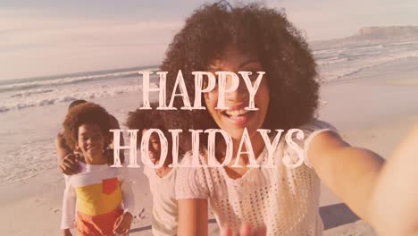 Animation-of-happy-holidays-text-over-african-american-family-on-the-beach