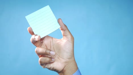 hand holding a blank sticky note