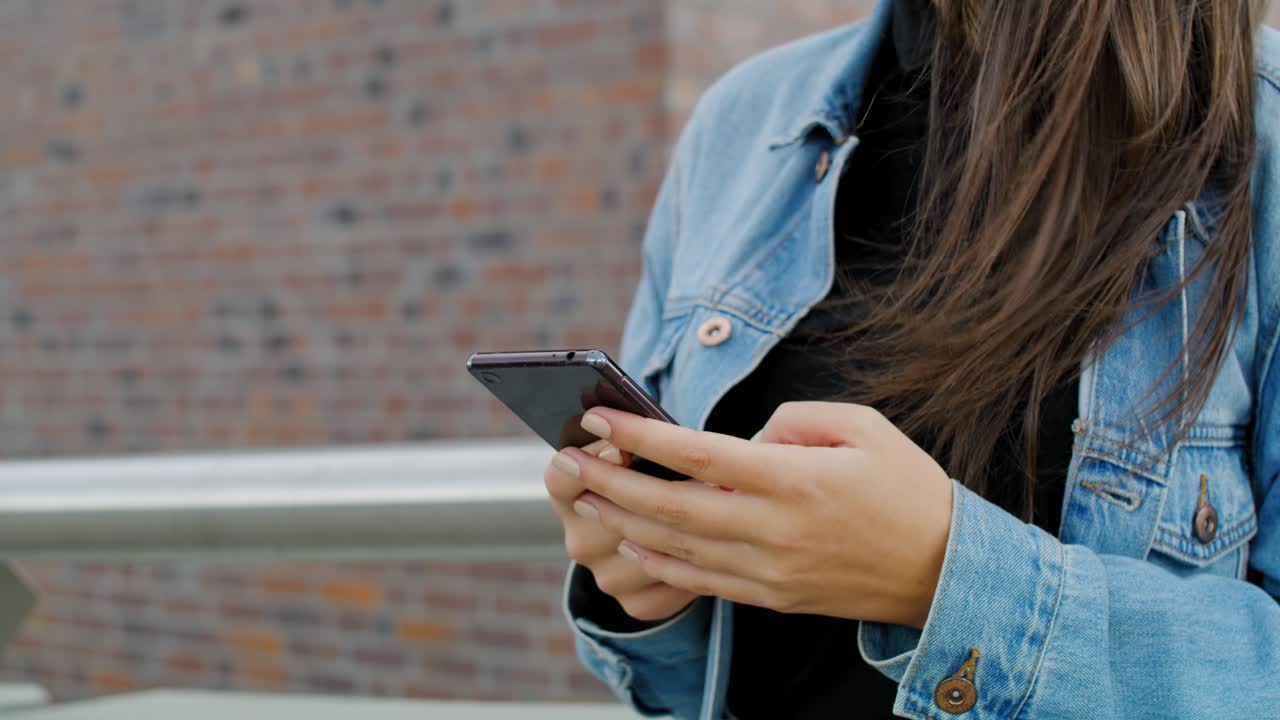 primer plano de una chica usando un teléfono inteligente al aire libre