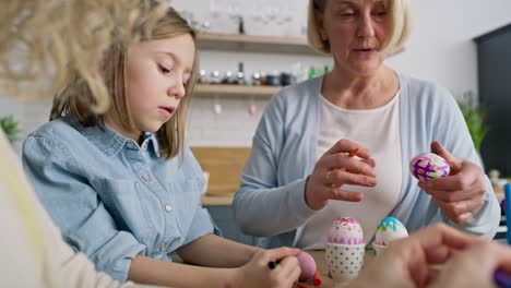 video of grandma and granddaughter during coloring easter eggs