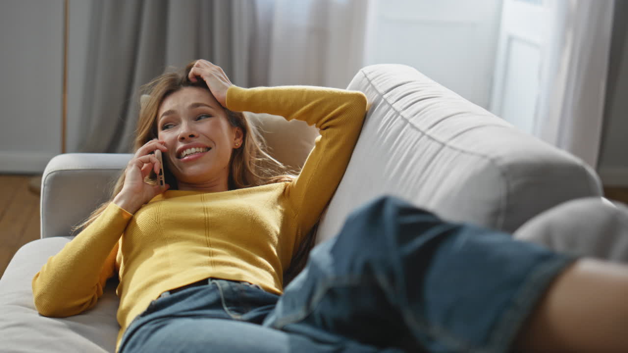 Positive lady speaking cellphone call chilling home zoom on. Woman laying sofa