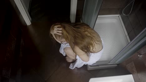 woman sitting in her shower crying her eyes out of anxiety