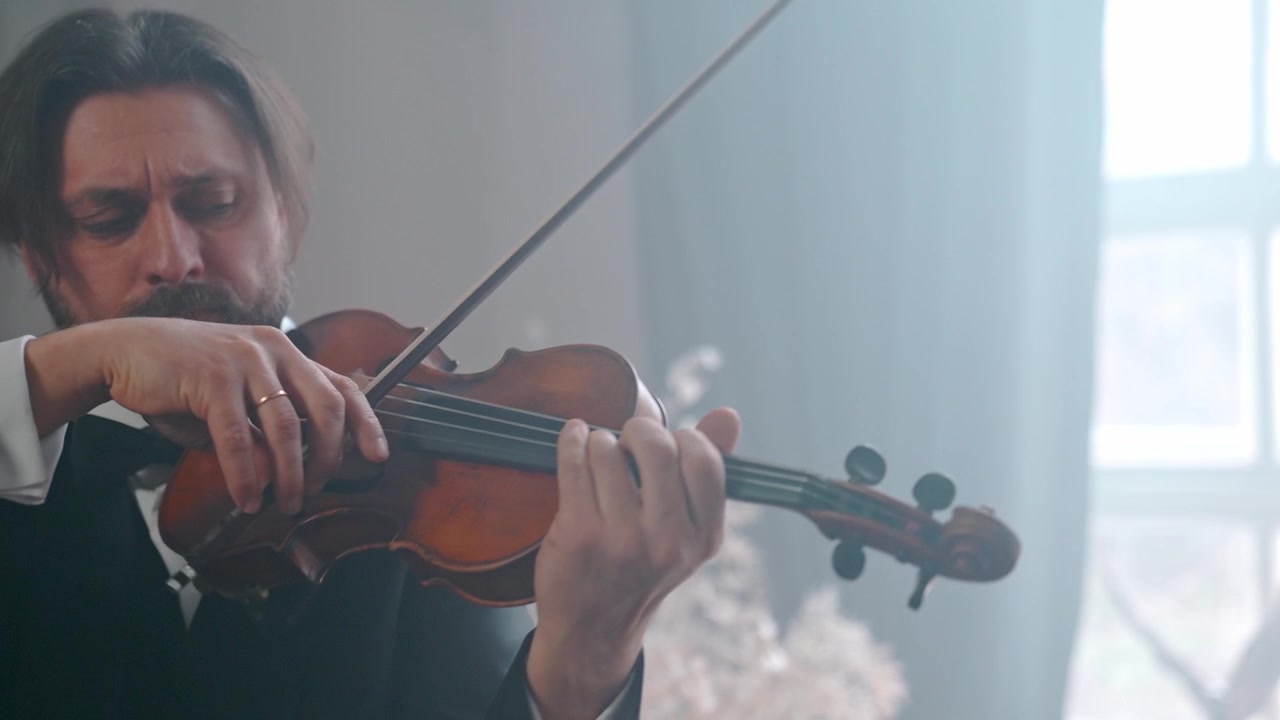 Uomo elegante in abito che suona il violino con concentrazione