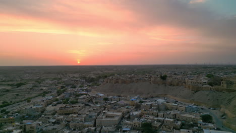 imágenes de drones que revelan una impresionante puesta de sol cerca del fuerte de jaisalmer, rajasthan, india, que combina elevación y panorámica suave