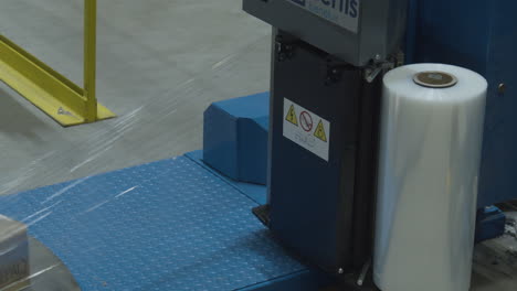 close up of automated plastic wrapper with plastic wrap being torn