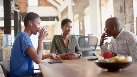 Happy-african-american-colleagues-talking-and-drinking-coffee-in-creative-office,-slow-motion