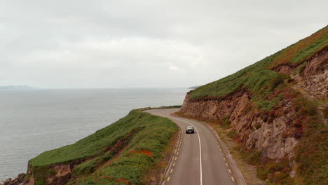 Vorwärtsverfolgung-Des-Autofahrens-Auf-Der-Straße,-Die-Sich-Entlang-Der-Meeresküste-Windet.-Panoramaweg-über-Der-Küste.-Irland