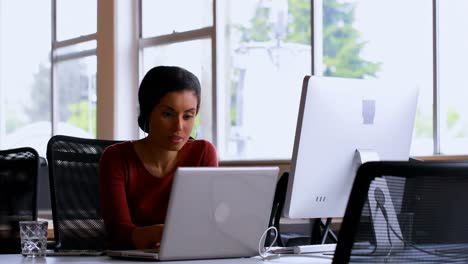 Female-executive-using-laptop-at-desk-4k