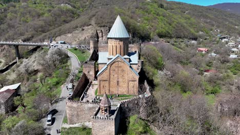 Complejo-Del-Castillo-Con-Iglesia-En-El-Río-Aragvi,-En-Georgia---Retroceso-Aéreo