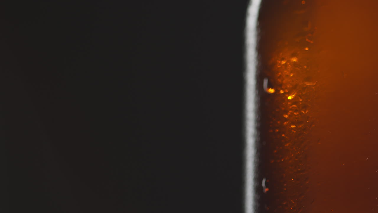 Pull Focus Close Up Shot Of Condensation Droplets On Revolving Bottle Of Cold Beer Or Soft Drink With Copy Space