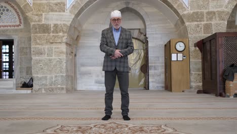 old man praying in mosque