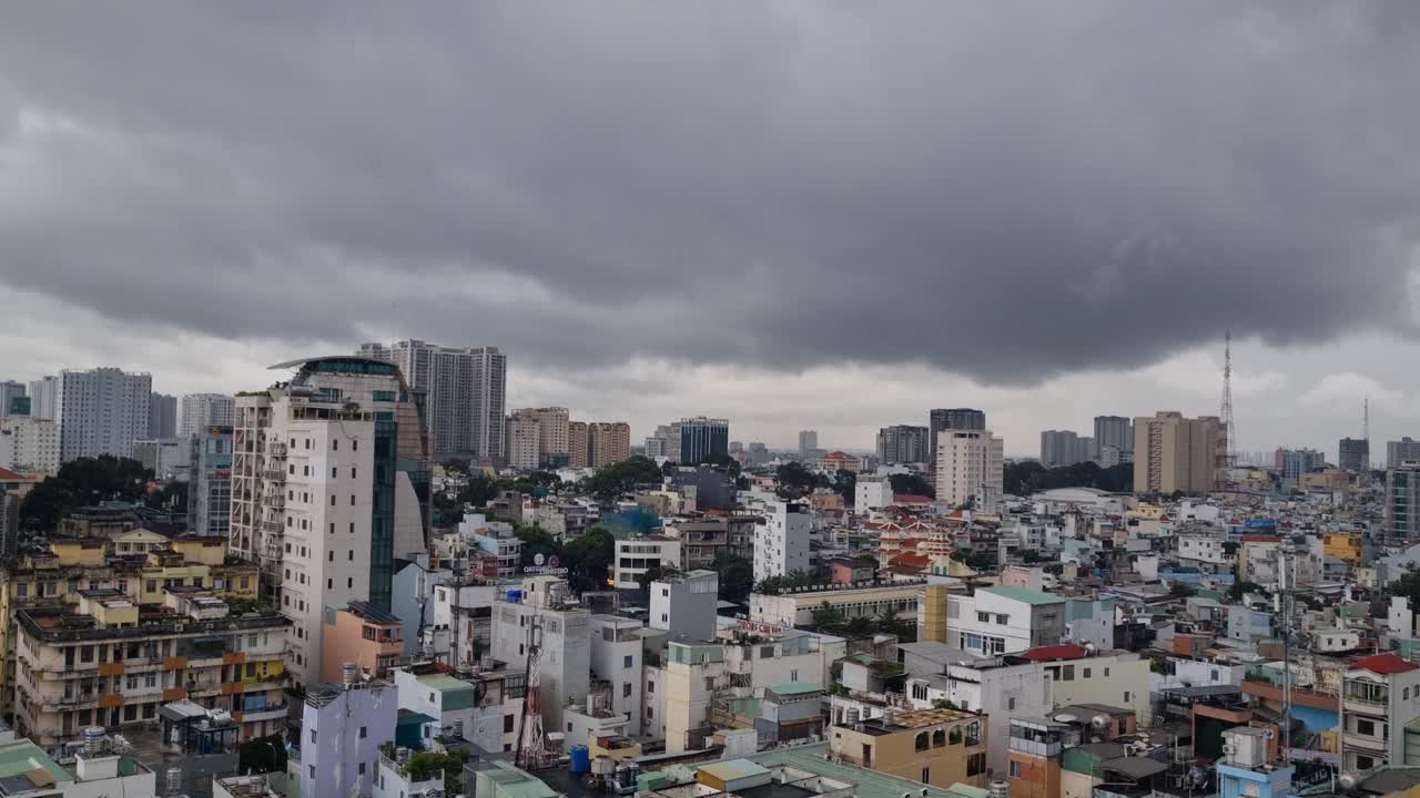 Aerial view of Ho Chi Minh City’s District 1 reveals a vibrant urban maze of towering skyscrapers, compact homes, and mid-rise blocks tightly packed together beneath a moody, overcast sky