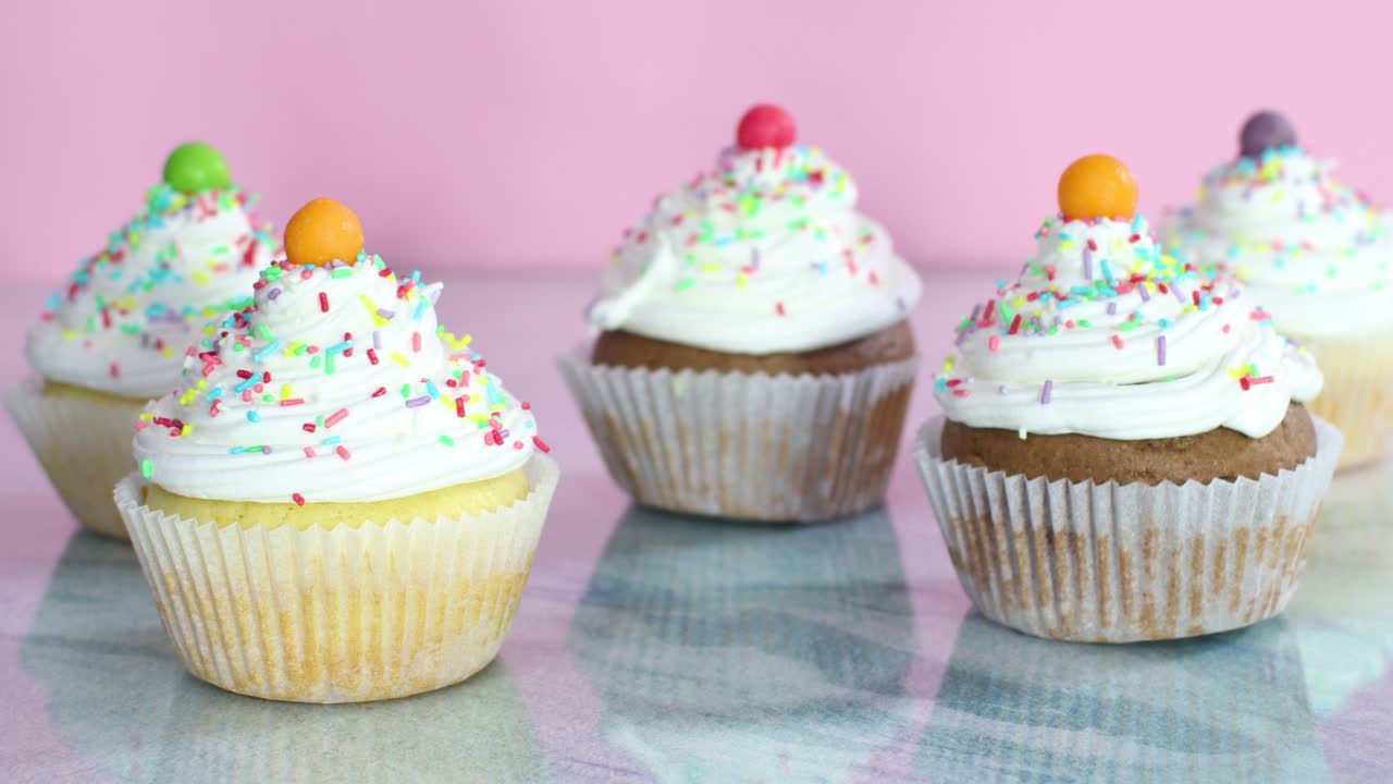 pasteles de taza dulces con crema blanca y migas en la mesa para la fiesta de cumpleaños