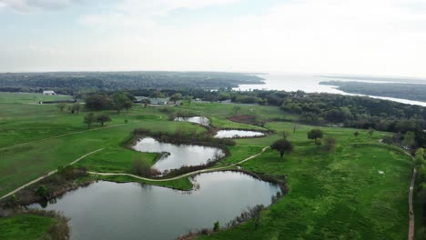 Majestuoso-Paisaje-Rural-Con-Pequeños-Estanques-Y-Un-Vasto-Río-A-Lo-Lejos