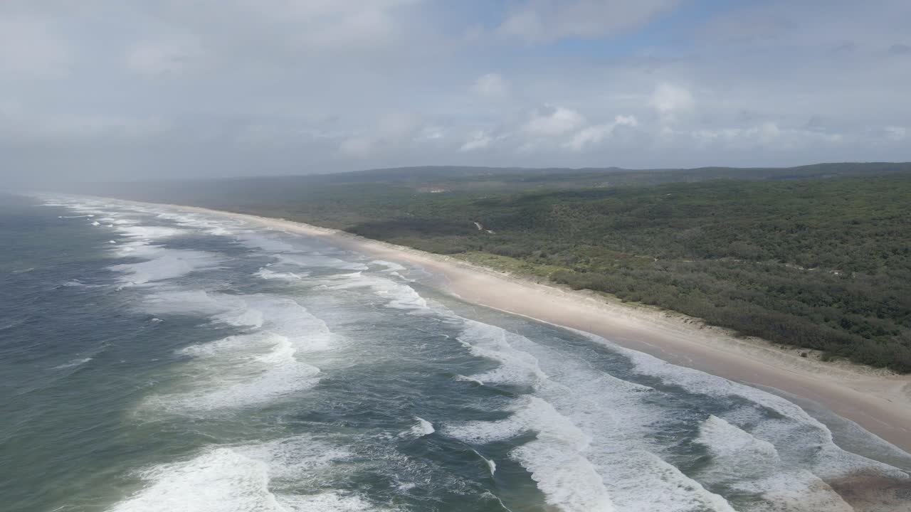 vista del largo tramo de la playa principal con paisaje con vegetación en la isla de north stradbroke, queensland, australia