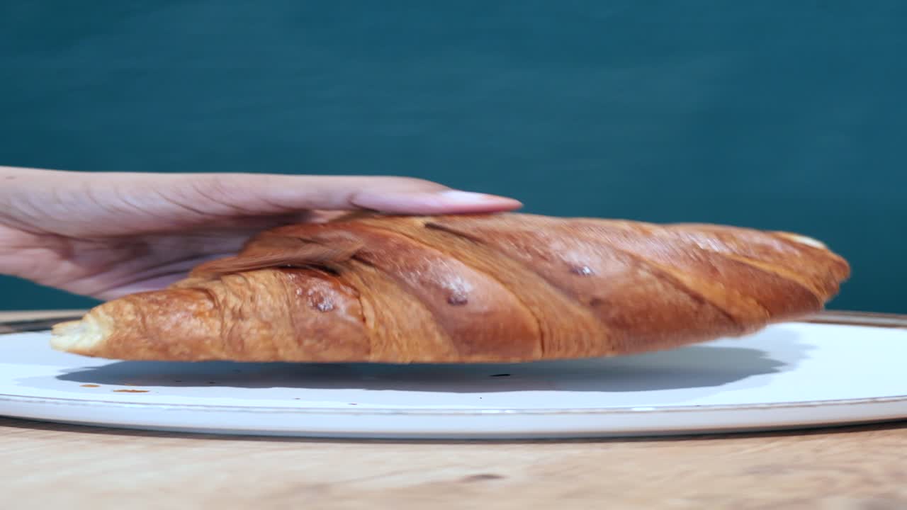 un croissant fresco y dorado en un plato blanco