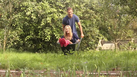 attractive young couple messing around with wheelbarrow