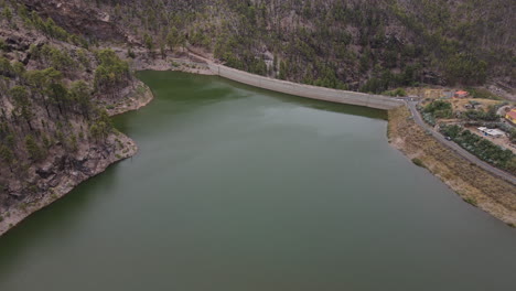 los perez dam: aerial view in orbit of the retaining wall of the dam located in artenara, gran canaria island on a sunny day