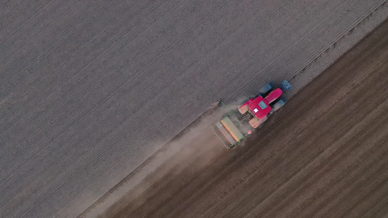 해가 지는 동안 농업 플랜테이션에서 일하는 트랙터