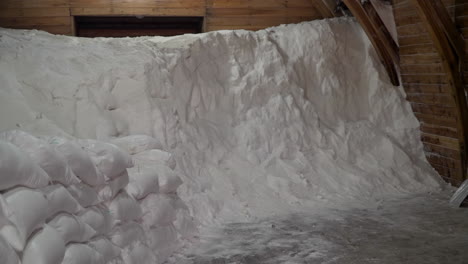 sacks of raw organic sea salt and storehouse huge pile of salt inside farm barn at gaetgol eco park