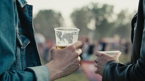 Close-up-of-unrecognizable-man-holding-a-disposable-cup-with-beer.