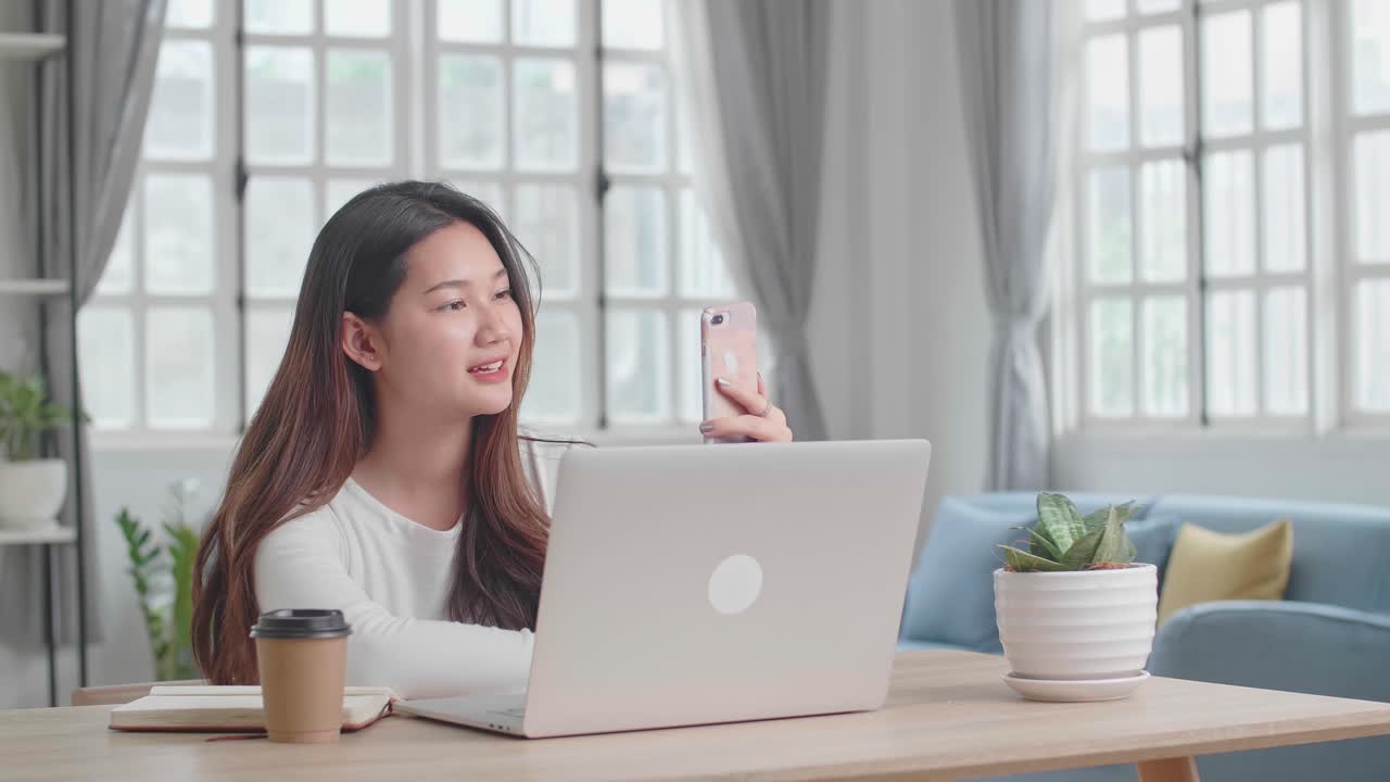 家からラップトップやスマートフォンを使って働く女性