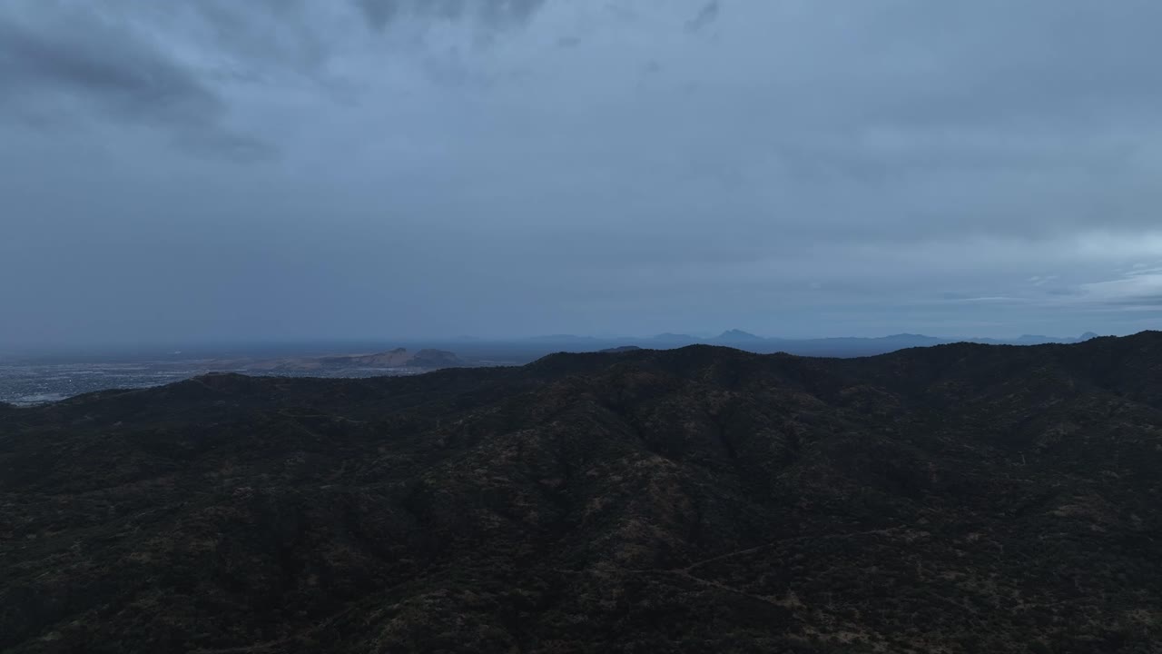 구름이 많은 날 산 위를 날아다니는 드론의 공중 촬영