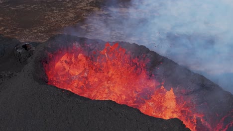 Hot-burning-lava-exploding-from-volcanic-crater-in-Iceland,-aerial