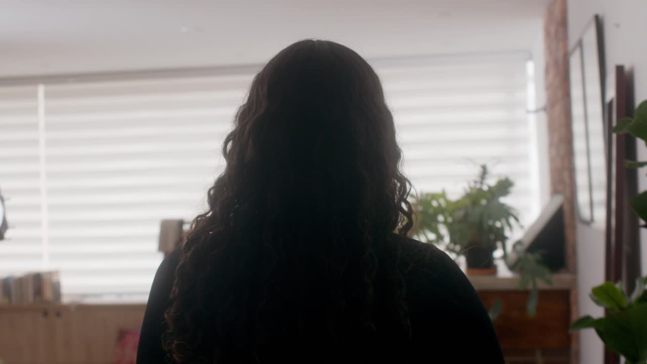 A woman's choosing clothes in her bedroom