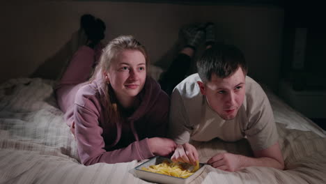 couple watching movie in bed