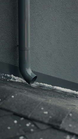 melting snow and water runoff from gutter