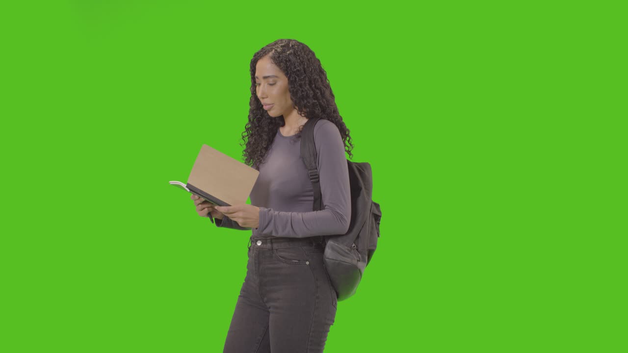 retrato de una estudiante universitaria o universitaria con mochila y cuaderno contra una pantalla verde sonriendo a la cámara