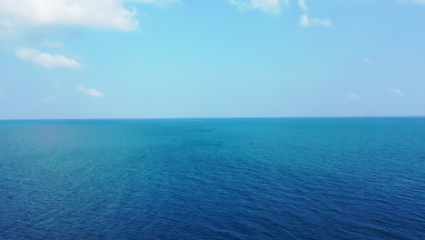 aerial seascape, open blue ocean, bright sky with clouds, abstract background with copy space