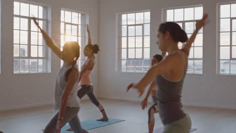 yoga class of healthy women practicing reverse warrior pose enjoying exercising in fitness studio instructor leading group meditation teaching workout posture at sunrise