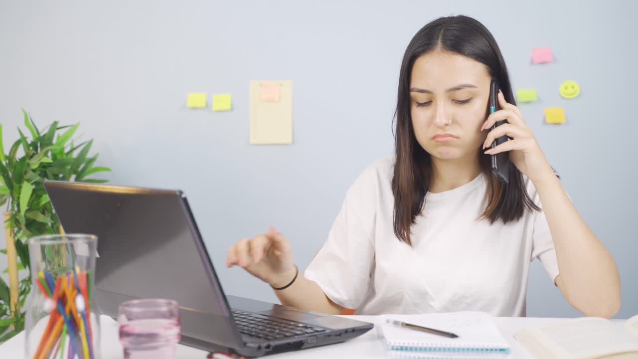una estudiante que habla infeliz por teléfono.