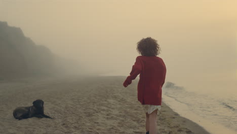 chica feliz corriendo en la playa del océano al amanecer. chica emocionada levantando las manos