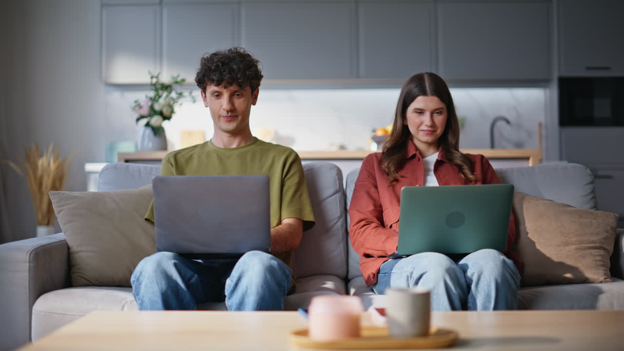 Involved freelancers working laptops together. Two people looking each other
