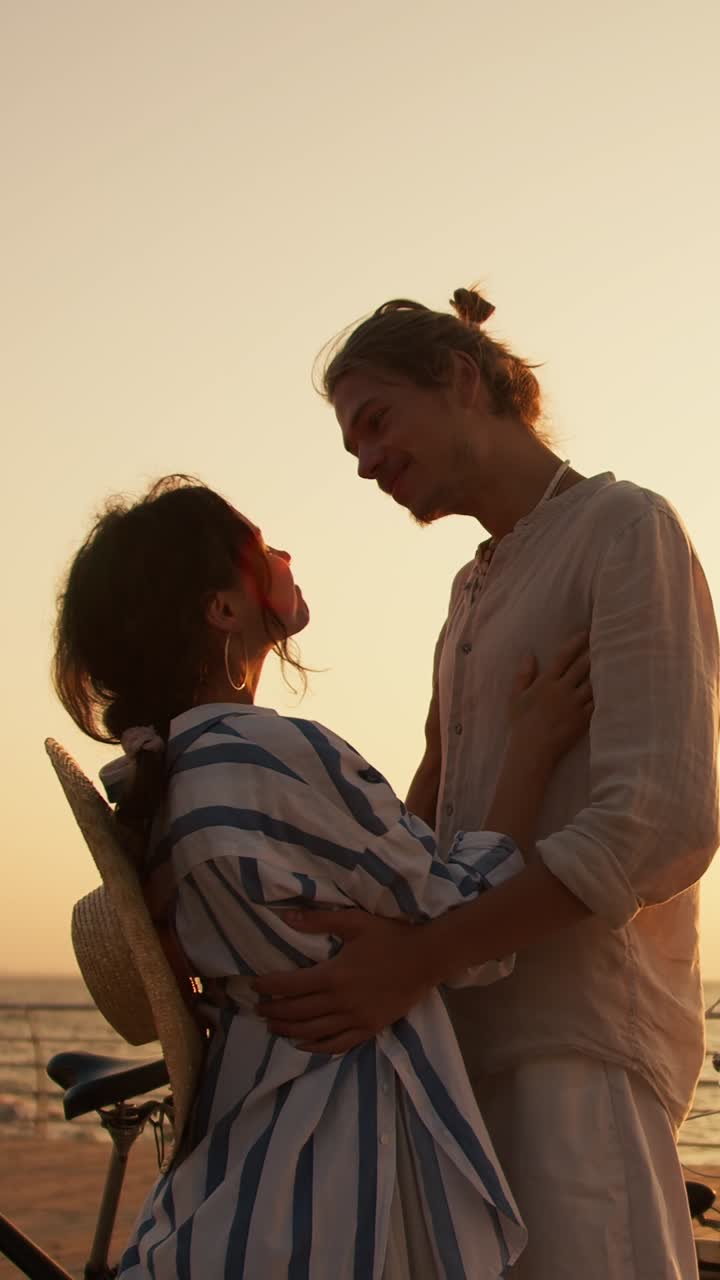 una pareja disfrutando de una puesta de sol en la playa