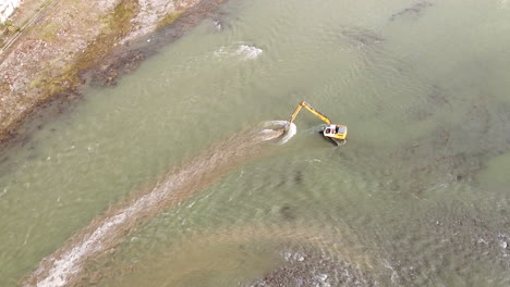 top view of water escavator working inside arno river near sieci town, pontassieve, to avoid another florence disaster flood afer latest november rainy long season