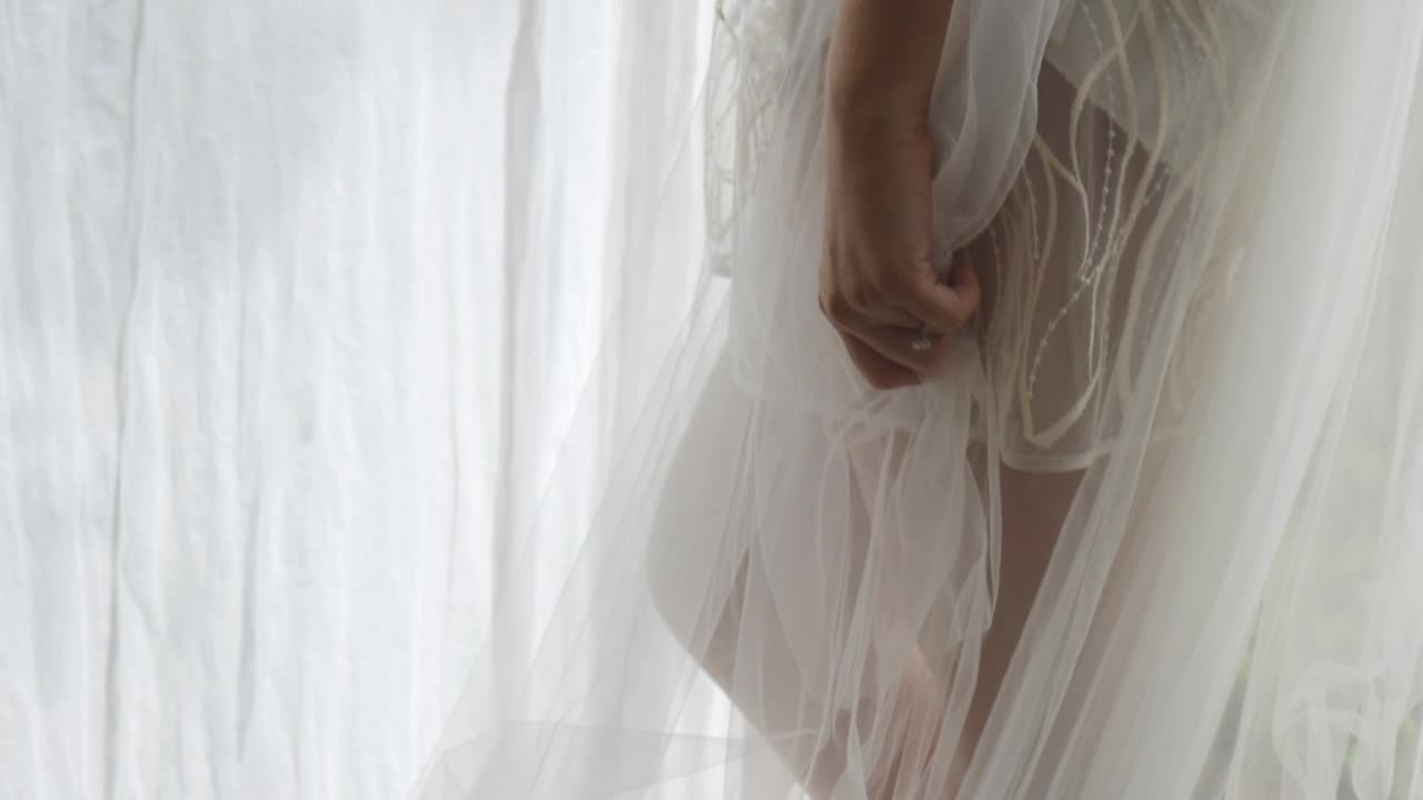 아름다운 신부가 결혼식의 아침에 휴식을 취하고 있습니다.